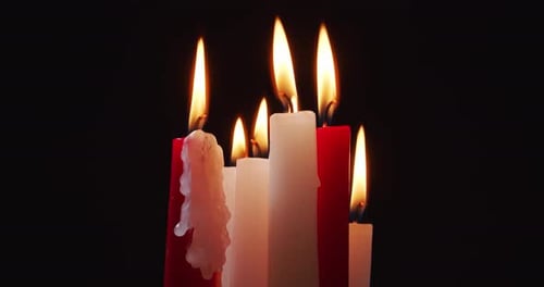 Burning White and Red Candles on a Black Background