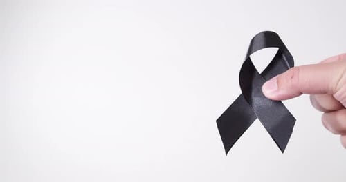 Black awareness ribbon on gray background. Mourning symbol, melanoma awareness, sleep disorders, and