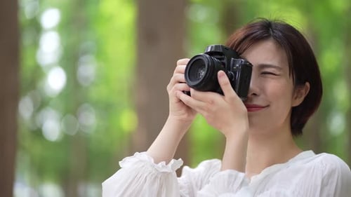 Woman Photographer Smiling in Forest