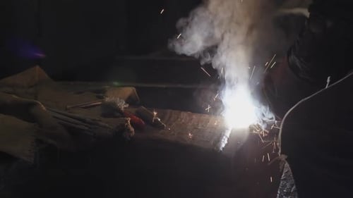 Welder Working with Torch Producing Sparks and Smoke