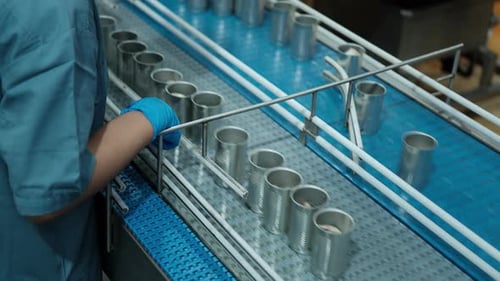 Metal Cans Moving Along a Conveyor Belt in Industrial Factory