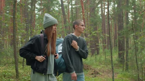 Close Up Of Siblings Adjusting Bags While Walking Through Forest Trail