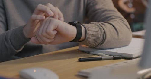 Person Using a Smart Watch at Desk