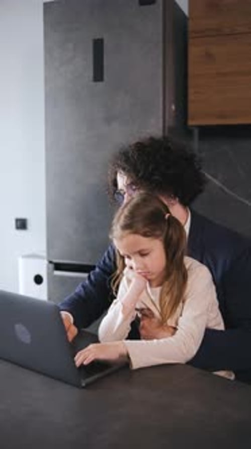 Man and Child Using Laptop Indoors