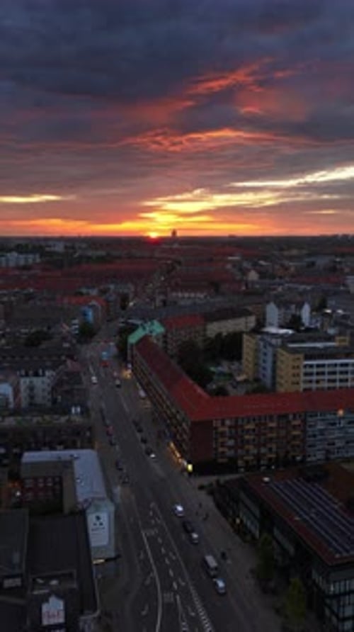 Aerial drone view of of Norrebro rooftops and streets during sunset, with dramatic golden sky over C