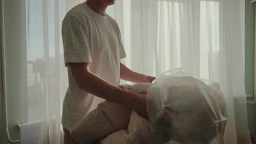 Couverture pour jeune homme dans un sac sous vide pour le rangement, gain de place, utilisation d'un aspirateur dans la chambre