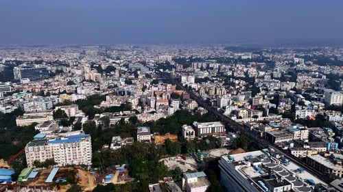 Drone shot capturing the cityscape of Hyderabad with mid-rise buildings, green cover, and a