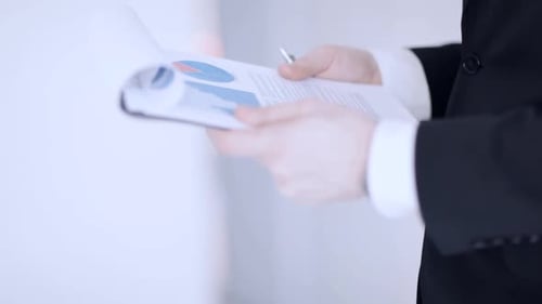Man in Suit Man Making Corrections in Document Agree