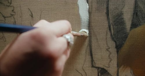 Artist Hand Painting White Paint on Canvas Close Up