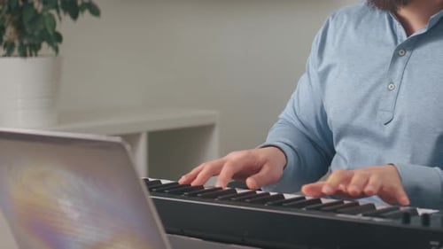 Man Playing Keyboard at Home During the Day