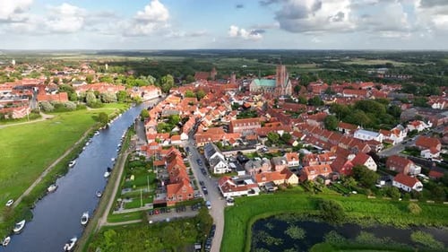 Reverse shot, moving backward to reveal the historic town of Ribe, with the majestic Ribe Cathedral,