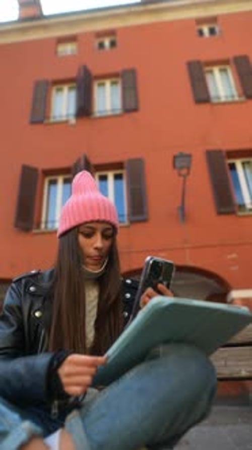 Woman Uses Tablet and Phone on City Bench
