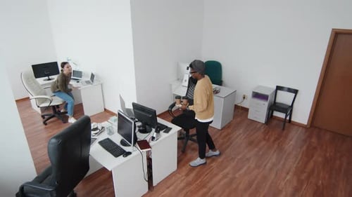 Office Workers Talking at Desks in Workplace