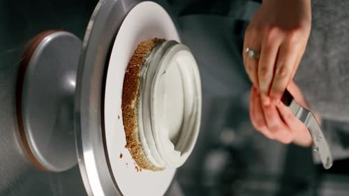 Vertical Video Close Up Female Baker in a Professional Close Up Kitchen Distributes Cream Onto