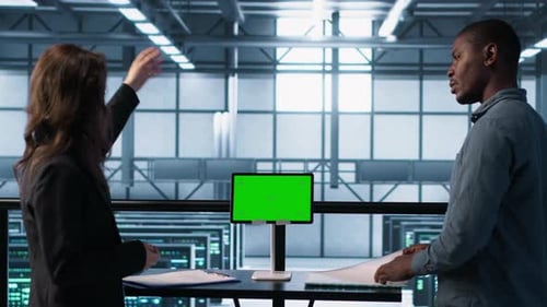Data Center Team Using Mockup Green Screen Tablet Reviewing Paperwork