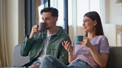 Couple Relaxing on Couch Chatting in Living Room