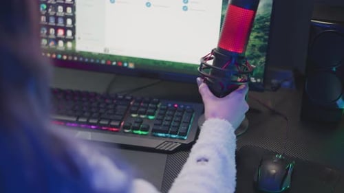 Woman Adjusts Microphone at Computer Station