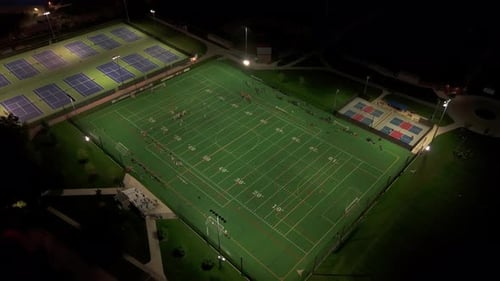 Wide Aerial View of American Football Teams of Play at Night Time