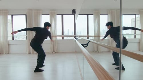 Young Man Practicing Contemporary Dance in front of Mirror at Studio