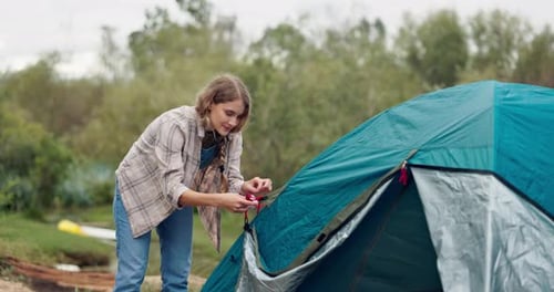 Young Adults Building a Tent in Nature