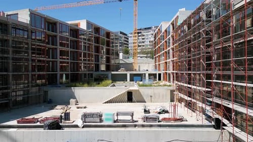 Edificios residenciales modernos en construcción con andamios y grúas capturados en un claro