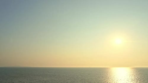 Endlose ruhige Meereslandschaft bei gelbgoldenem Sonnenuntergang, Reflexion des Sonnenlichts auf der Meerwasseroberfläche