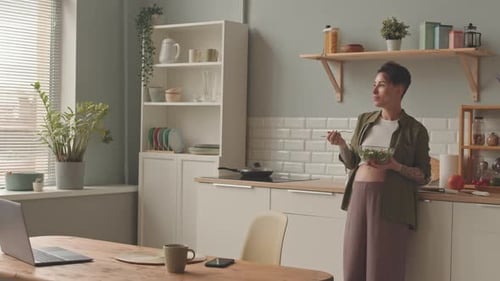 Pregnant Woman Eating Green Salad at Kitchen