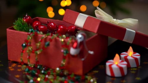 Close Up of Red Open Box with Gifts of Christmas Decorations Rotates on Tray