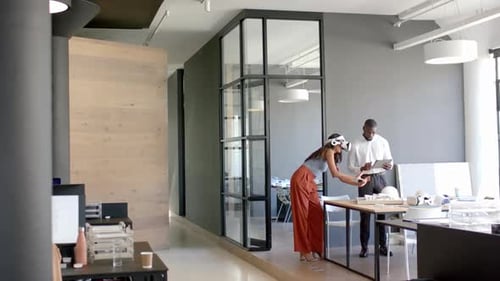 Business diverse colleagues discussing work, using tablet and documents in modern office