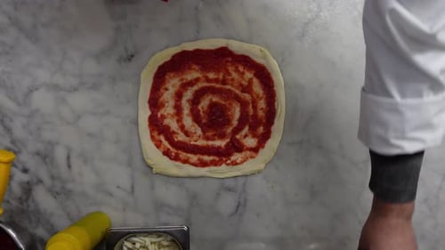 Italienischer Koch bereitet eine Pizza zu