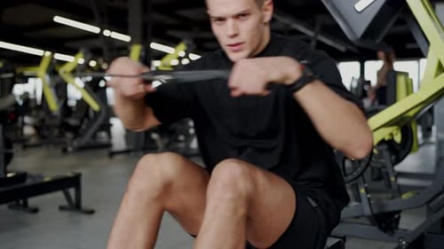 Young Man Exercising at a Modern Gym Intense Workout Focus