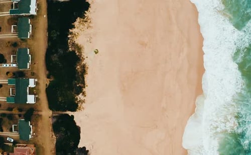 4k drone footage of a coastline alongside a city