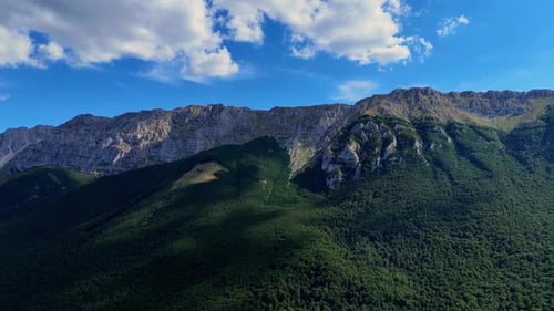 drone flies over a rocky mountain, clouds in the sky