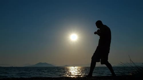 Silhouette of Boxer Training on Beach at Sunrise