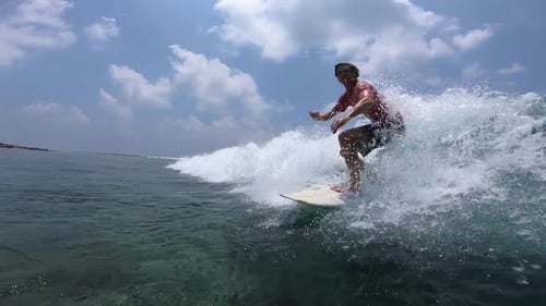 Surfer Rides Ocean Wave on a Sunny Day