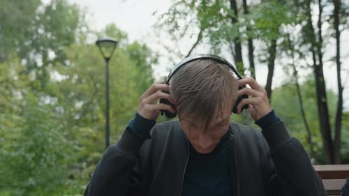 Man Tests Sound Individual Experiences Immersive Sound Amidst Rainy Park Environment Man Captures