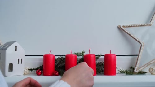 Weibliche Hände basteln vier rote Adventskerzen, Tannenzweige und Weihnachtsdekorationen ohne Abfall in