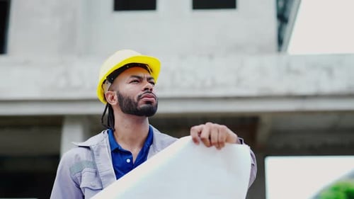 Latin male Engineer checking blueprints