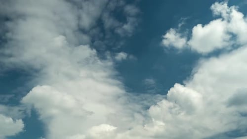 Fluffy White Clouds Slowly Drifting Across the Sky