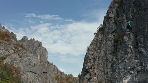 Drone Shot of a Brave Man Climbing a Cliff