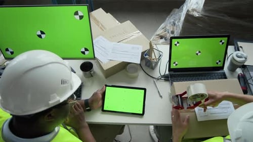Black Man and Woman Managing Logistics with Green Screen Devices