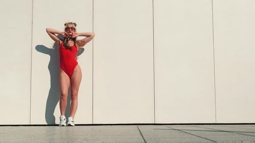 Stylish Woman Posing in Red Bathing Suit on Cityscape