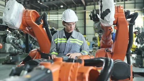Nach der Installation eines Programms auf dem Roboterarm eine Ingenieurin mit einer Roboterarmsteuerung