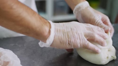 Arbeiter backen Brotlaib mit Teig auf sauberem Tisch in Zeitlupe