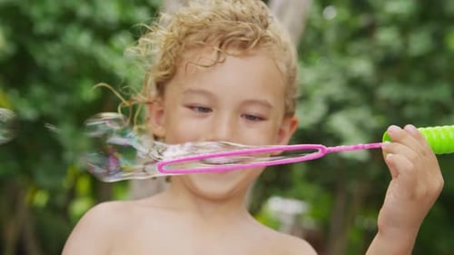 Boy Blowing Bubbles. Shot On Red Epic For High Quality 4k, Uhd, Ultra Hd Resolution.