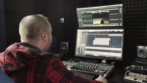 Sound Engineer Working in Recording Studio A Sound Engineer with a Flannel Shirt is Mixing Audio on