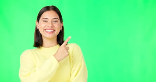 Portrait, pointing and product placement with a woman on green screen in studio for marketing