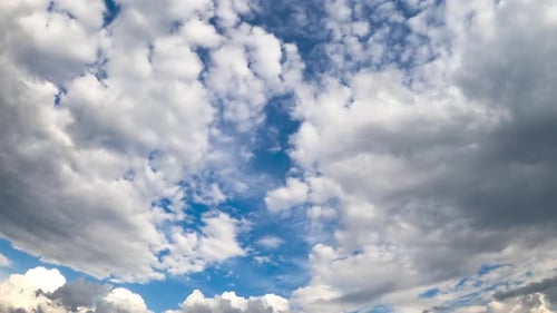 Soft white clouds covering the blue sky. Low angle view timelapse on summer daytime.