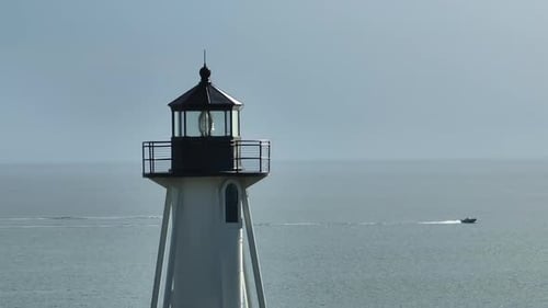 Weißer hoher Leuchtturm an der Küste vor blauem Himmel für die Schifffahrt von Handelsschi