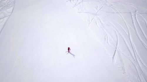 Aerial of ski resort at sun mountains with pine forest. Skiers ride down on snow slope at lifts. Win